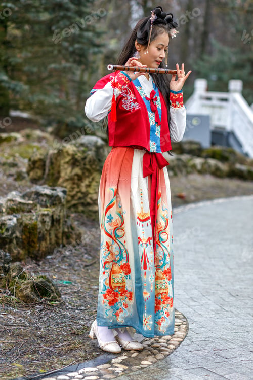 Preview: A woman in red Chinese costume walks in the park,plays the bamboo flute.Celebrating Chinese New Year