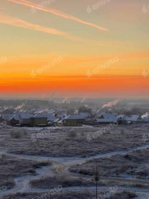 Preview: Bright sunset over a snow-covered field and village on a winter evening