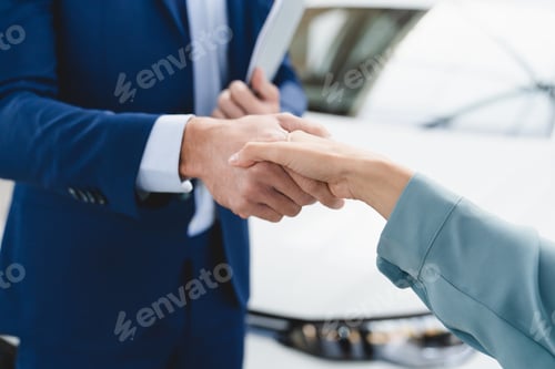Preview: Shop assistant handshake with female customer client after buying purchasing new car. Good deal.