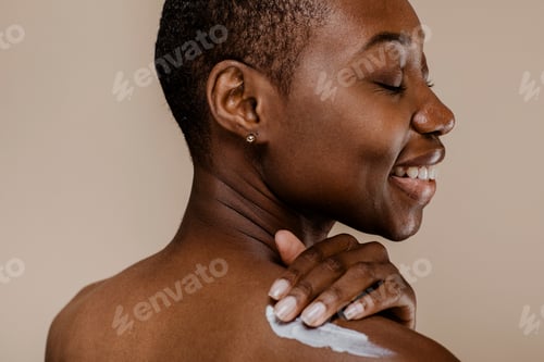 Preview: Black woman applying body cream