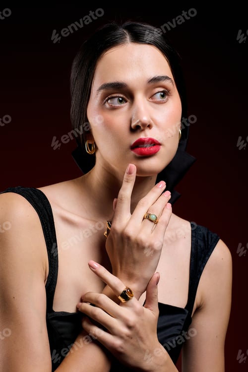 Preview: Stylish woman showcasing elegant jewelry with a mysterious expression and glamorous makeup