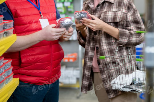 Preview: Young woman choosing nails in hardware store