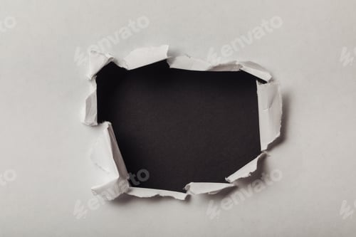 Preview: torn hole in sheet of paper on black background