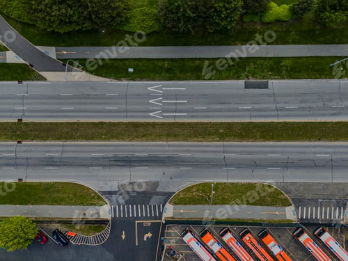 Preview: Top down shot over an empty road on a sunny day with green landscaping in the area.