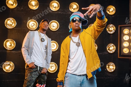 Preview: Two black rappers in caps on stage with spotlights