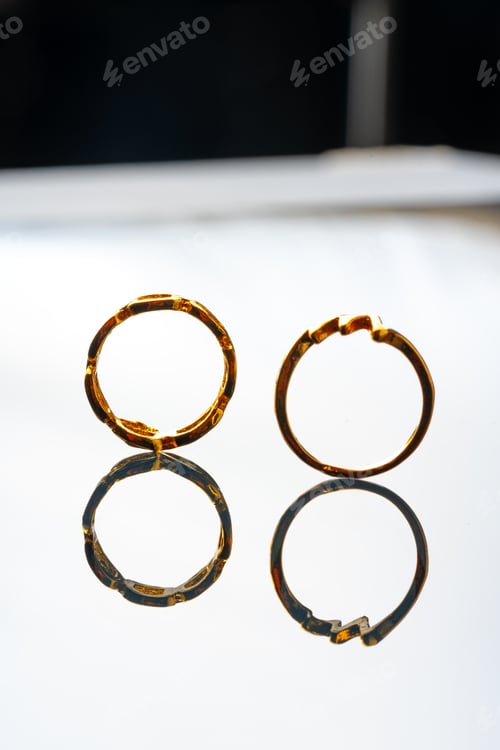 Preview: Two golden rings on glass background close up