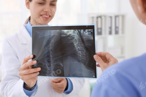 Preview: Doctor and nurse examining MRI scan in hospital, closeup