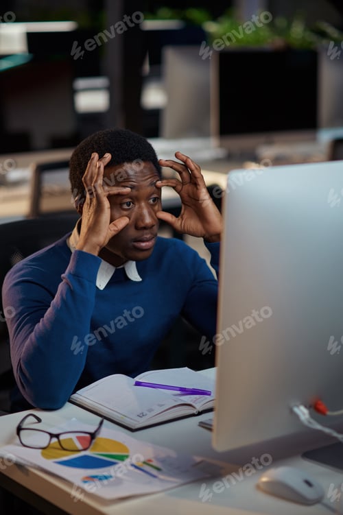 Preview: Tired young manager works in night office