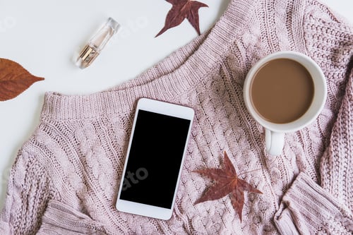 Preview: Empty screen smartphone with cup of coffee and dried autumn leaves and sweater, Top view