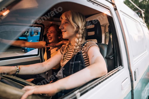 Preview: Friends sharing a laugh on a road trip in a vintage van.