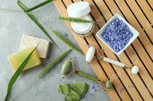 Vista previa: Skin care beauty concept with face rollers on gray textured background