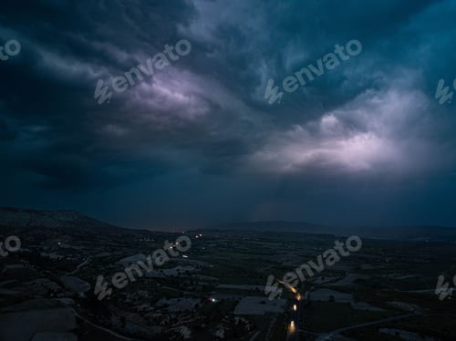 Preview: Stormy sky over rural landscape at dusk with lightning.