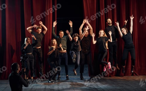Preview: Group of actors in dark colored clothes on rehearsal in the theater
