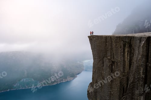 Preview: Preikestolen, Norway A view from the top of the Pulpit Rock in Norway, with two figures standing on
