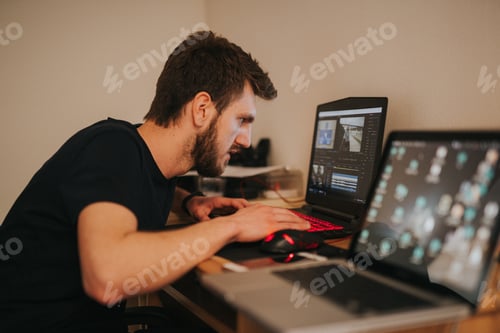 Preview: Handsome man sitting and working on his computer at home