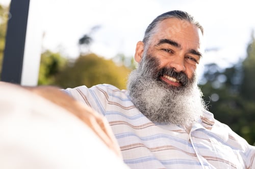 Preview: Smiling senior man with beard relaxing outdoors in casual shirt