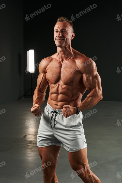 Preview: the caucasian athlete's fists are clenched, the whole body with a naked torso is in tension. muscles