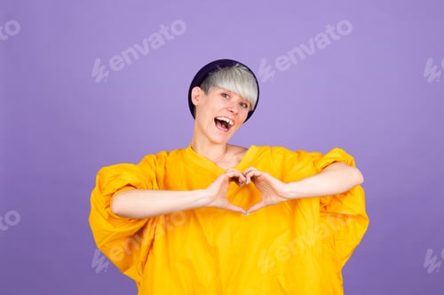 Preview: Stylish european woman on purple background shows heart with hands love concept copy space