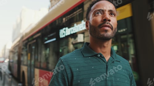 Vista previa: Close-up of young man walking in front of passing bus in the background