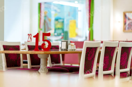 Preview: Vibrant Restaurant Interior With Red Number 15 on Table and Colorful Artwork in Background