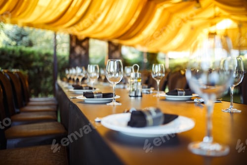 Preview: Sparkling glassware stands on long table prepared for wedding dinner.