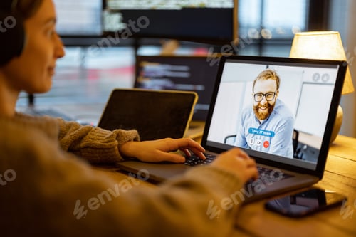 Preview: Woman talking online with a male colleague at home office