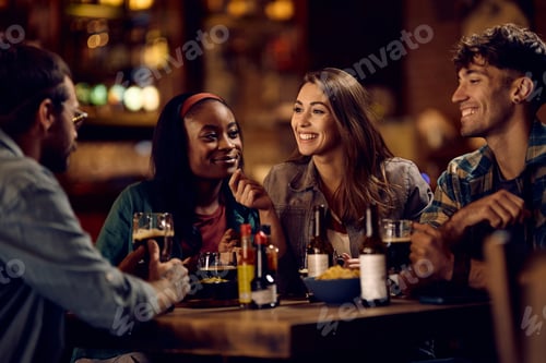 Preview: Group of happy friends communicating while enjoying their night out in a bar.