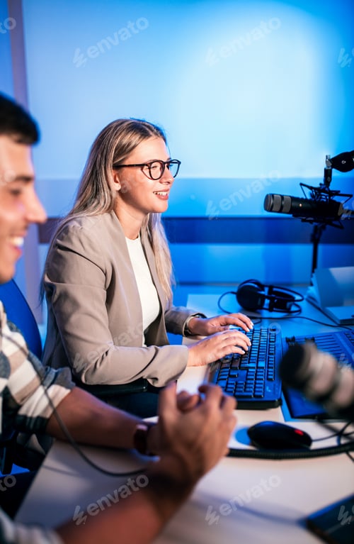 Preview: Young woman and man editing audio podcast in their studio.