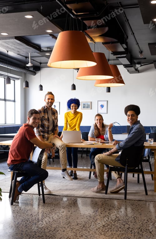 Preview: Portrait of diverse male and female colleagues using laptop in casual office meeting
