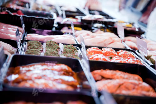 Preview: Variety of fresh meat products in refrigerator at butchers shop
