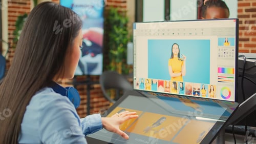 Preview: Female colorist editor using retouching software with tablet