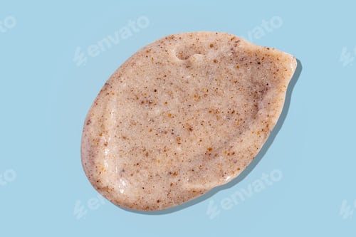Preview: Scrub smear swatch isolated on blue background. Peeling cream smudge with exfoliating particles