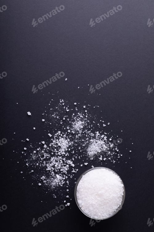 Preview: Directly above shot of salt in dish and fallen on black table with copy space