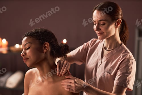 Preview: Woman receiving relaxing shoulder massage in spa