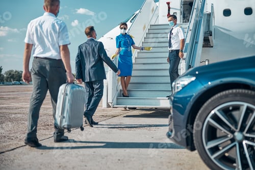 Preview: Stewardess and pilot meeting vip passenders on stairway