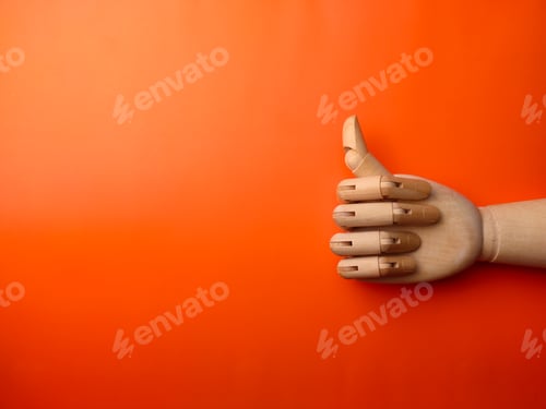 Preview: Top view wooden hand with thumb up on a orange background