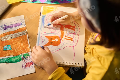 Preview: Young Girl Drawing Colorful Animal Picture at Wooden Table