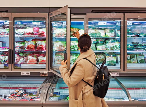 Preview: Rear view of young woman shopping for food in groceries store