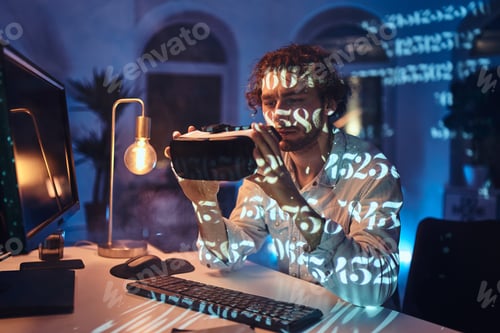 Preview: Futuristic virtual glasses its holding by pensive guy in dark room