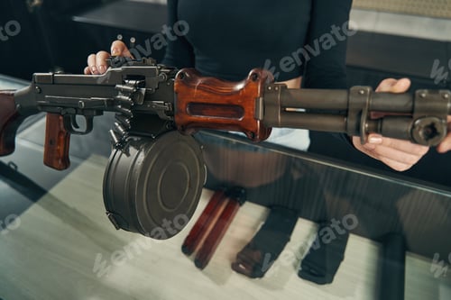 Preview: Experienced salesperson demonstrating a weapon to buyers at the counter
