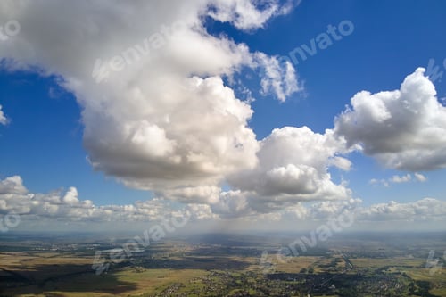 Preview: Aerial view from high altitude of earth covered with white puffy cumulus clouds on sunny day