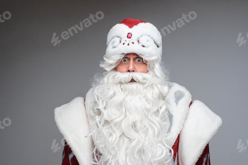 Preview: Frighted Santa with white beard looking at camera.