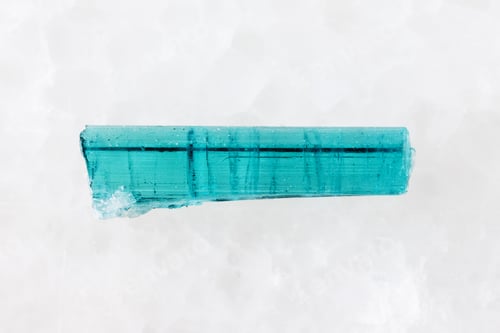 Preview: sample of rough indigolite crystal on white marble