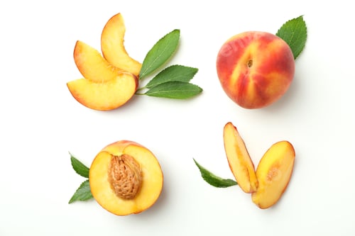 Preview: Ripe peach fruits with leaves on white background