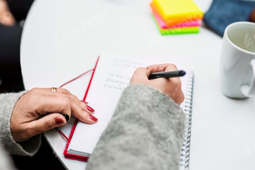Preview: Cropped image of businesswoman writing in diary during business meeting