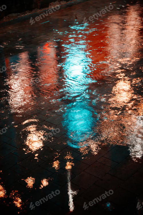 Preview: Raindrops on asphalt in the light of evening lights