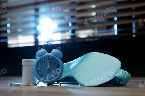 Preview: Alarm clock, sleeping mask and pills on table indoors. Insomnia treatment