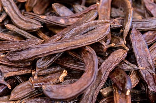 Preview: Close up of carob pods heap or Ceratonia siliqua background