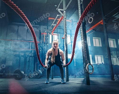 Preview: Woman with battle rope battle ropes exercise in the fitness gym.