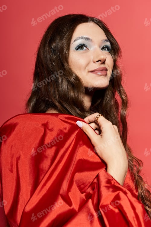 Preview: A lovely young woman in a vibrant red outfit poses gracefully against a warm backdrop